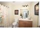 Clean bathroom with vanity, toilet, shower with curtain, and framed art at 10038 Hemlock Way, Jonesboro, GA 30238