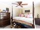 Bright bedroom with four-poster bed, ceiling fan, and dark wood furniture at 10038 Hemlock Way, Jonesboro, GA 30238