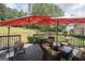 Inviting outdoor deck with wicker furniture and shade umbrellas overlooking a beautifully landscaped yard and wooded area at 10038 Hemlock Way, Jonesboro, GA 30238