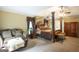 Beautiful main bedroom featuring a seating area, four-poster bed, and natural light at 10038 Hemlock Way, Jonesboro, GA 30238
