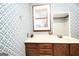 This bathroom features a vanity with drawers and patterned wallpaper at 1502 Campground, Mcdonough, GA 30252