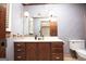 Bathroom featuring a wood vanity, framed mirror, and striped wallpaper at 1502 Campground, Mcdonough, GA 30252
