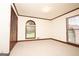 Spacious bedroom with neutral carpet, wood trim, and arched window overlooking the yard at 1502 Campground, Mcdonough, GA 30252