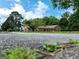 Low angle view of brick home exterior with mature trees creating a peaceful setting at 1502 Campground, Mcdonough, GA 30252