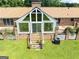A sunroom with large windows and a backyard patio with brick pillars in a landscaped backyard at 1502 Campground, Mcdonough, GA 30252