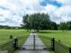 Gated driveway leads to expansive country estate with lush green fields and mature trees at 1502 Campground, Mcdonough, GA 30252