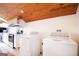 Laundry room with full-sized washer and dryer with adjacent kitchen featuring white cabinetry at 1502 Campground, Mcdonough, GA 30252