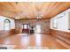 Open room with hardwood floors, brick accents, a wood stove, and a decorative stained glass window at 1502 Campground, Mcdonough, GA 30252