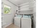 Laundry room featuring a pair of white washer and dryers, shelving, and natural light at 2826 Summit Ridge Dr, Marietta, GA 30066