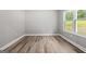 Well-lit bedroom with wood-look flooring, a large window, and neutral paint at 5341 Stewart Mill Rd, Douglasville, GA 30135