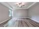 Spacious bedroom featuring hardwood flooring, a tray ceiling with ceiling fan, and natural light at 5341 Stewart Mill Rd, Douglasville, GA 30135