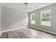 Empty bedroom featuring wood-style flooring and two bright, tree-lined windows at 5341 Stewart Mill Rd, Douglasville, GA 30135