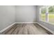 Bright, empty bedroom with wood-look floors and a large window overlooking the yard at 5341 Stewart Mill Rd, Douglasville, GA 30135
