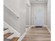 Welcoming entryway featuring wood stairs, wood-look floors, and a painted entry door at 5341 Stewart Mill Rd, Douglasville, GA 30135