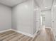 Hallway with gray walls, white trim, hardwood floors, and white doors leading to different rooms at 5341 Stewart Mill Rd, Douglasville, GA 30135