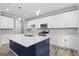 Modern kitchen features white cabinetry, stainless steel appliances, and a large island with a navy blue base at 5341 Stewart Mill Rd, Douglasville, GA 30135