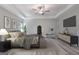 Spacious main bedroom with tray ceiling, ceiling fan, accent furniture, and wall-mounted television at 5341 Stewart Mill Rd, Douglasville, GA 30135