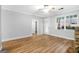 Open-concept living room with wood floors and a stone fireplace with ample light from the door and windows at 1283 Mercer, East Point, GA 30344