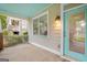 Inviting covered porch with a bright turquoise door and ceiling, and classic lantern lighting at 1283 Mercer, East Point, GA 30344