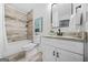Updated bathroom with tiled shower, granite countertop, and white vanity with framed mirror at 1092 Donnelly Sw Ave, Atlanta, GA 30310