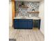 Basement bar with a modern tile backsplash, dark blue cabinets, and a wine cooler at 2410 Thrasher Rd, Buford, GA 30519