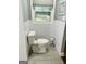 The bathroom features a toilet with tiled walls and a window view at 2410 Thrasher Rd, Buford, GA 30519