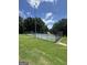This tennis court is surrounded by fencing, trees and a patch of grass at 25 Castlehill Ct, Covington, GA 30016