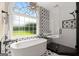 Elegant bathroom featuring a soaking tub, walk-in shower, and a decorative star light fixture at 411 Hickory Fairway Ct, Woodstock, GA 30188