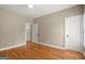 Bedroom features hardwood floors and a neutral color scheme, complemented by natural light from a window at 411 Hickory Fairway Ct, Woodstock, GA 30188