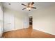 Bedroom with light walls, wood floors, and view into open kitchen at 411 Hickory Fairway Ct, Woodstock, GA 30188
