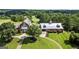 Aerial view of a red barn and connected building with green lawn and landscaping at 411 Hickory Fairway Ct, Woodstock, GA 30188