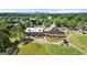 Aerial view of a red barn building with a silver roof, landscaping and golf carts parked outside at 411 Hickory Fairway Ct, Woodstock, GA 30188