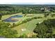 Aerial view of a lush golf course with multiple ponds, sand traps, and tree-lined fairways at 411 Hickory Fairway Ct, Woodstock, GA 30188
