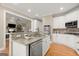 Modern kitchen featuring granite countertops, white cabinets, and stainless steel appliances at 411 Hickory Fairway Ct, Woodstock, GA 30188