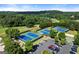 Aerial view of blue tennis courts next to a parking area, surrounded by lush, mature trees at 411 Hickory Fairway Ct, Woodstock, GA 30188