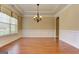 Elegant dining room boasts hardwood floors, wainscoting, modern chandelier, and natural light at 4924 Locklear Way, Marietta, GA 30066