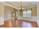 Dining room featuring hardwood floors, wainscoting, modern chandelier, and archway to another room at 4924 Locklear Way, Marietta, GA 30066