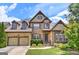 Two-story brick home with a two-car garage, well-manicured landscaping, and covered front porch entry at 4924 Locklear Way, Marietta, GA 30066