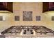 Close up on a stovetop with stainless steel appliances, dark wood cabinets, and granite countertops and tile backsplash at 4924 Locklear Way, Marietta, GA 30066
