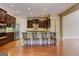Kitchen with stainless steel appliances, dark wood cabinets, granite countertops, and seating at the island at 4924 Locklear Way, Marietta, GA 30066