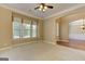 Neutral living room featuring a ceiling fan, large windows, and archway to another room at 4924 Locklear Way, Marietta, GA 30066