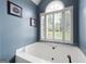 Stylish bathroom features a large soaking tub, shuttered windows, and modern fixtures at 5418 Amity Dr, Powder Springs, GA 30127