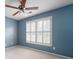 Bedroom with blue walls, a ceiling fan, and large windows with white plantation shutters at 5418 Amity Dr, Powder Springs, GA 30127