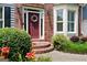 Close-up front door featuring a decorative wreath, brick stairs, and vibrant flowers, enhancing its inviting charm at 5418 Amity Dr, Powder Springs, GA 30127