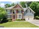 Attractive two-story home showcasing a brick facade, complemented by a well-maintained lawn and an attached two-car garage at 5418 Amity Dr, Powder Springs, GA 30127