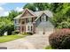 Charming two-story home with a brick and siding exterior, a two-car garage, and well-manicured landscaping at 5418 Amity Dr, Powder Springs, GA 30127