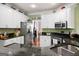 Stainless steel appliances, granite countertops, and white cabinets are featured in this kitchen view at 5418 Amity Dr, Powder Springs, GA 30127