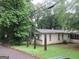 Modest single-story home featuring neutral siding and a screened-in porch, nestled in a wooded landscape at 125 Highland Cir, Stockbridge, GA 30281