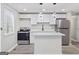 Modern kitchen featuring stainless steel appliances, white cabinets, and a kitchen island at 2106 Singer Way, Lithonia, GA 30058
