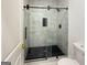 Elegant bathroom featuring a glass shower, tile surround, and black hardware at 243 Roxbury Dr, Riverdale, GA 30274